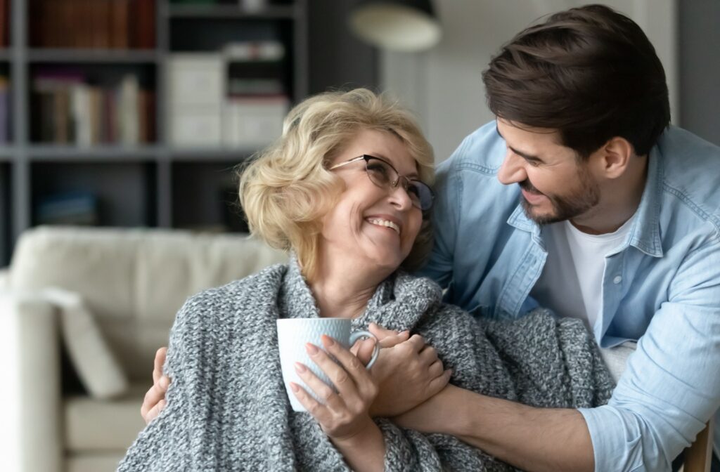 An adult child embracing their mature parent in assisted living.